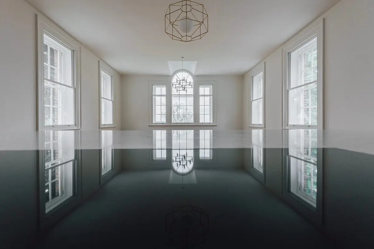 Restored principal room with tall sash windows and herringbone floor